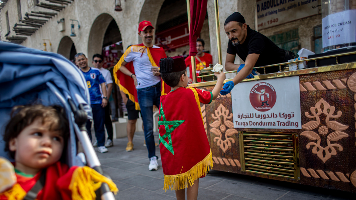 Un niño vestido con los colores marroquíes recibe un helado en el mercado tradicional Souq Waqif.