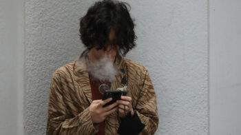 Un joven 'vapeando' un cigarrillo electrónico, afuera de un edificio en China, el 29 de abril de 2022. 