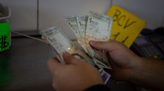 Un vendedor cuenta billetes de un millón de bolívares, el 23 de septiembre de 2022, en Caracas (Venezuela).