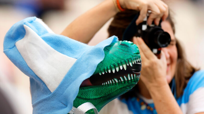 Una fanática con la camiseta de Argentina le toma la foto a una mascota antes de la final ante Francia.