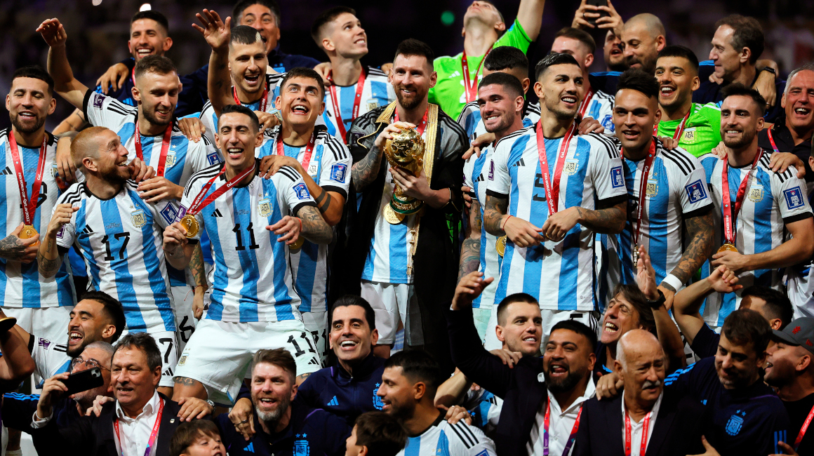 Los jugadores argentinos se reúnen alrededor de la Copa del Mundo.