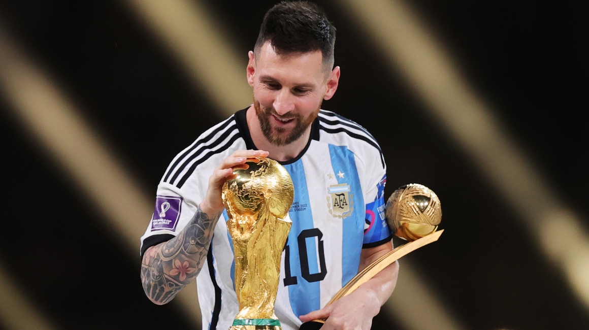 Lionel Messi toca el trofeo de la Copa del Mundo tras ganar el balón de oro del torneo, el 18 de diciembre de 2022.