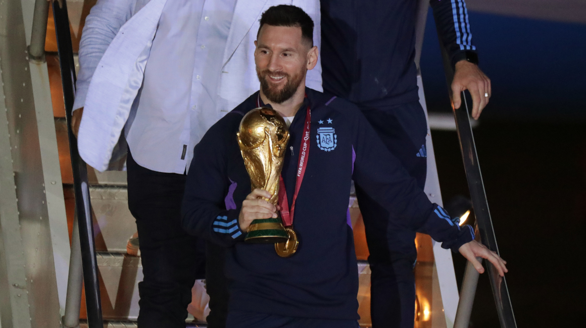 Lionel Messi desciende con el trofeo del Mundial de Fútbol Qatar 2022 a su llegada al Aeropuerto Internacional de Ezeiza, el 20 de diciembre de 2022.