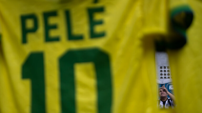 Imagen de una camiseta de venta con el nombre de Pelé, el número 10 y un hincha de fondo.