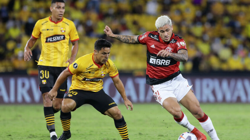 Matías Oyola cubre una pelota ante un futbolista de Flamengo, en un partido por Copa Libertadores, el 29 de septiembre de 2021.