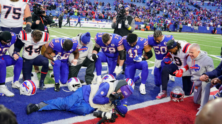 Los miembros de los Buffalo Bills y los New England Patriots rezan en el medio del campo después del partido en el Highmark Stadium.