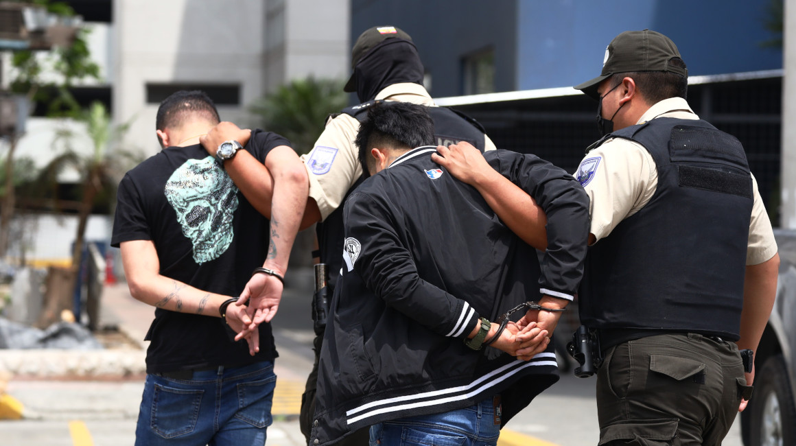 Agentes policiales custodian a los dos detenidos como sospechosos por la balacera y asesinato en el Omni Hospital de Guayaquil, el 11 de enero de 2023.