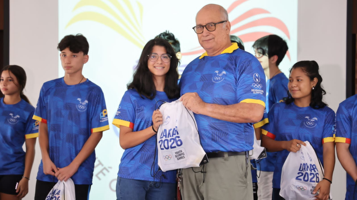 Jorge Delgado, presidente del COE, entrega implementos deportivos a los jóvenes atletas.
