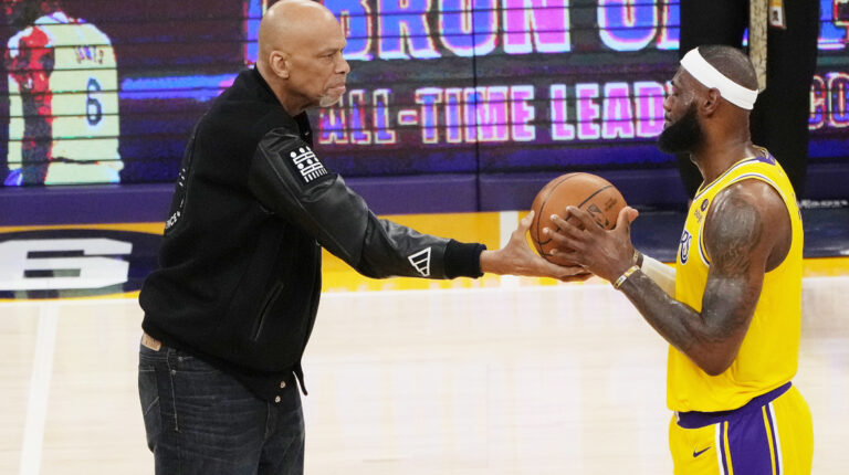 El legendario Kareem Abdul-Jabbar le entrega la pelota a LeBron James, después de que James rompiera el récord como máximo anotador en la historia de la NBA, el 7 de febrero de 2023.