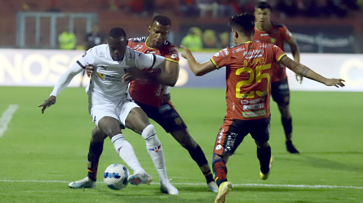 Los jugadores del Deportivo Cuenca y Liga de Quito disputan una pelota en la Fecha 1 de la LigaPro 2023, el 24 de febrero.