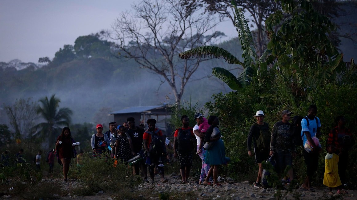 Migrantes hacen fila en Bajo Chiquito, en la selva del Darién, para ser trasladados a una estación humanitaria.