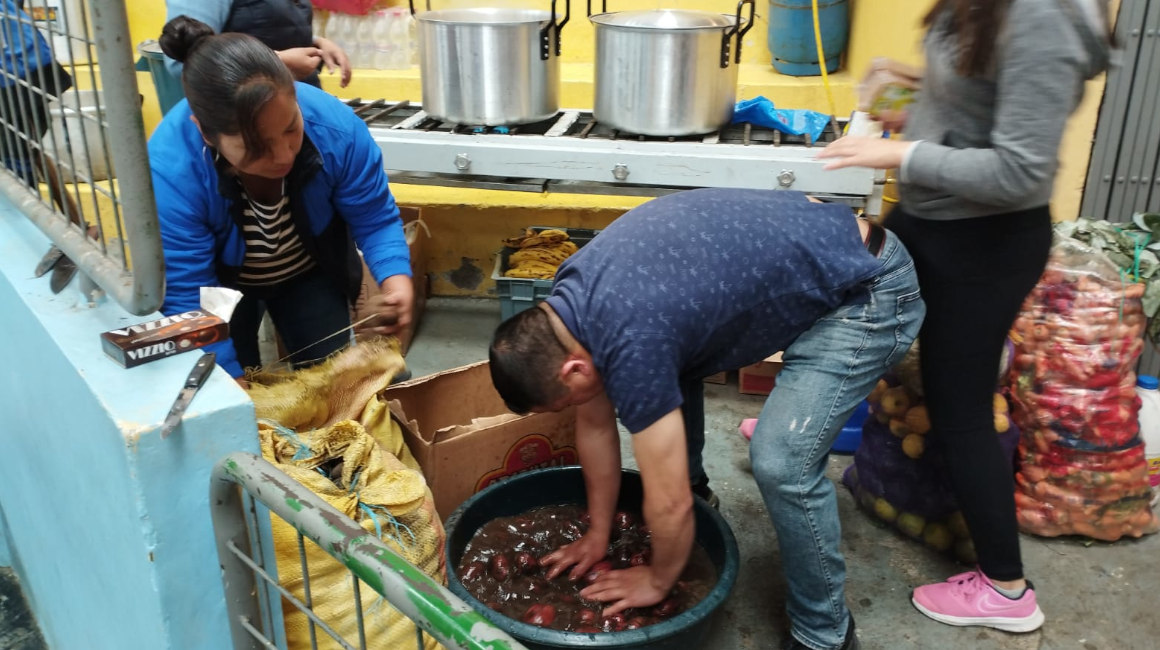 Uno de los ayudantes lava las papas donadas para Alausí. 
