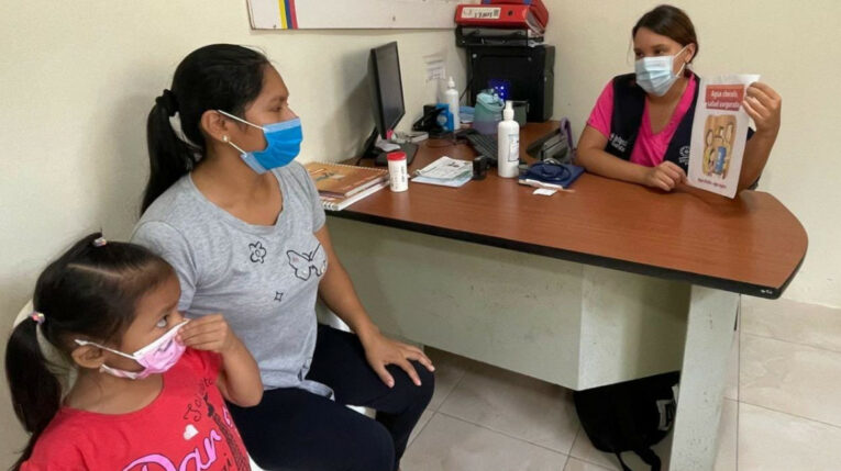 Una madre y su hija reciben charlas sobre el virus de la influenza y el Covid-19, en un centro de salud público en un sector de Guayaquil, el 12 de abril de 2023. 