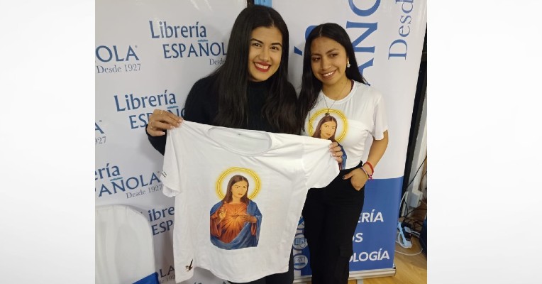 La escritora Ariana Godoy recibe una camiseta con su imagen hecha por la ecuatoriana Paula Villegas.