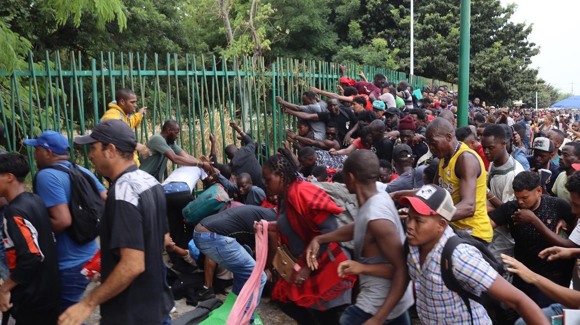 Grupos de migrantes rompen el cerco de seguridad para exigir papeles migratorios hoy, Tapachula, estado de Chiapas (México).