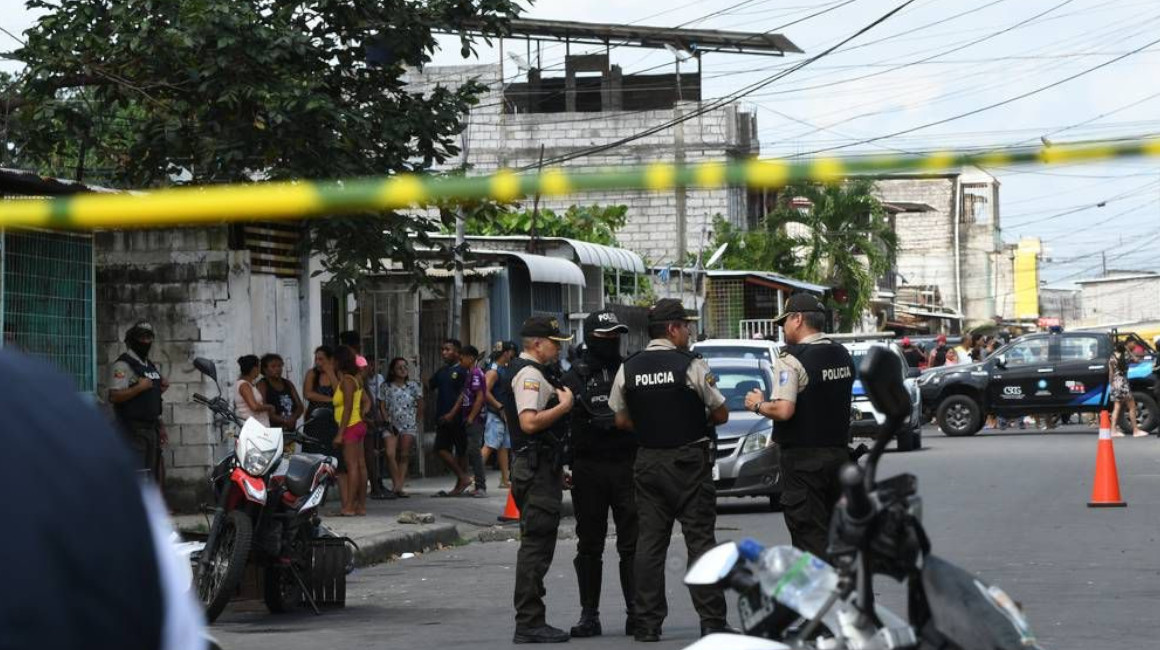 Policías junto a los cuerpos de los fallecidos en la isla Trinitaria, en Guayaquil, el 4 de junio de 2023. 