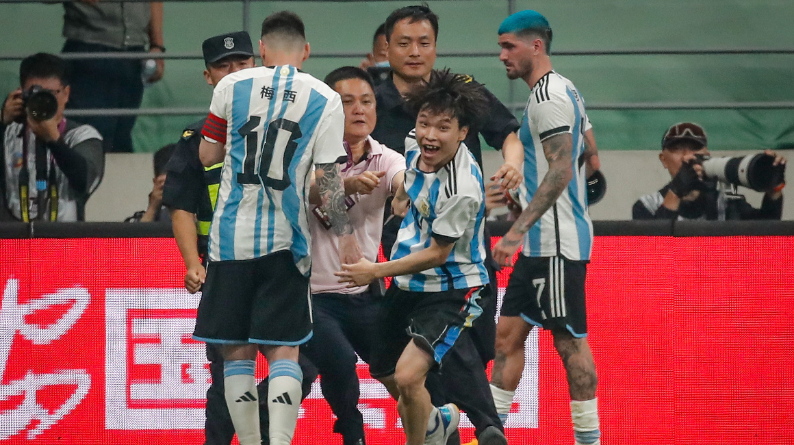 Un aficionado es perseguido por seguridad después de abrazar a Lionel Messi de Argentina durante el partido amistoso de fútbol entre Argentina y Australia, el 15 de junio de 2023.