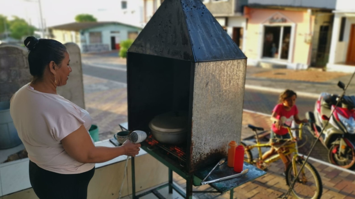 Gabriela Valenzuela, propietaria de la picantería Gaby, en Puerto Baquerizo Moreno (Galápagos), cocina los alimentos en carbón, ante la escasez de gas en las islas, el 20 de junio de 2023.
