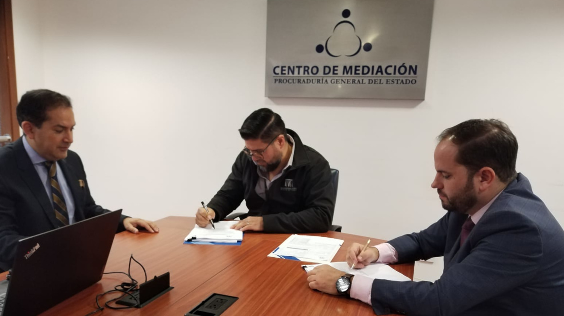 El gerente del Metro de Quito, Víctor Hugo Villacrés (izquierda), junto a representantes de la empresa CAF, en el cierre del proceso de mediación de los trenes, el 23 de junio de 2023.