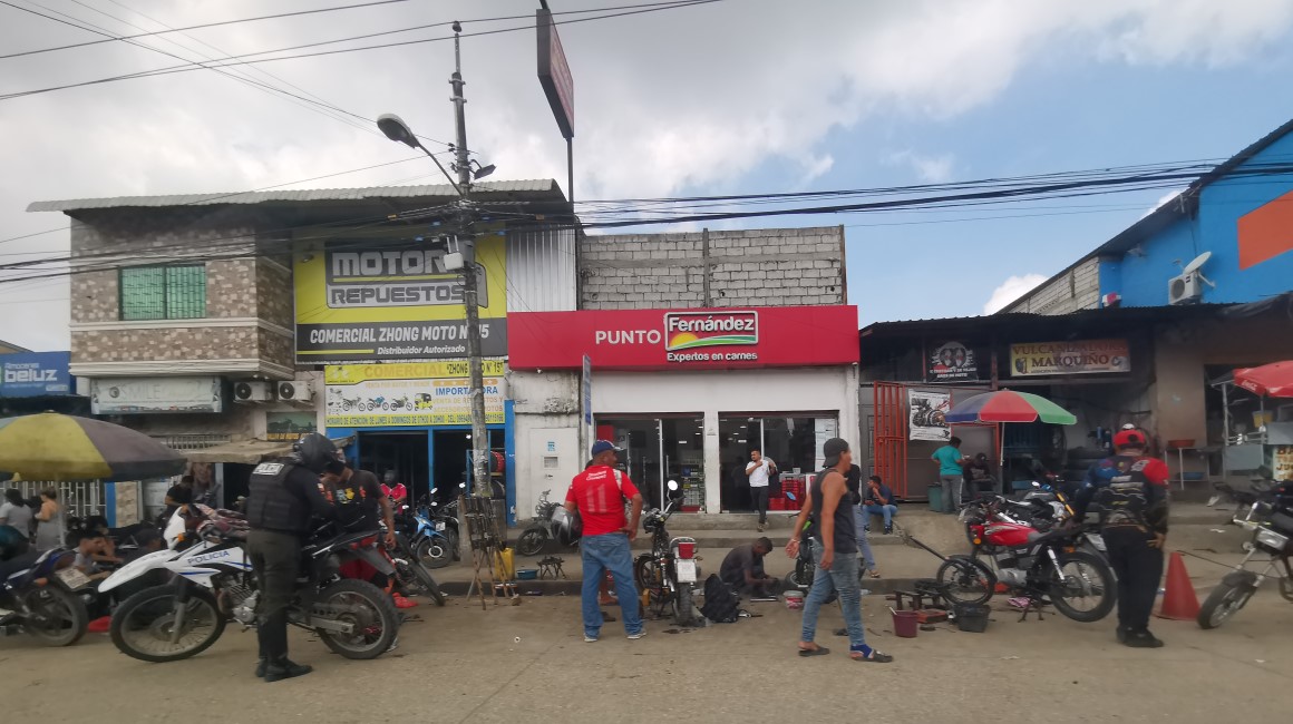 Un policía revisa su moto en un sector comercial en la entrada de la 8, al noroeste de Guayaquil.