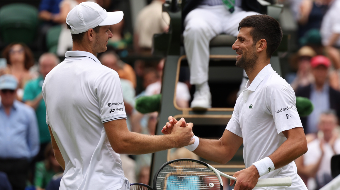 Novak Djokovic le da la mano a Hubert Hurcacz, después de ganar su cuarto partido en Wimbledon, el 10 de julio de 2023.