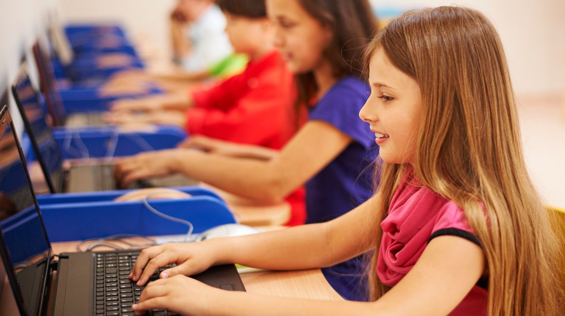 Niños estudiando en computadoras