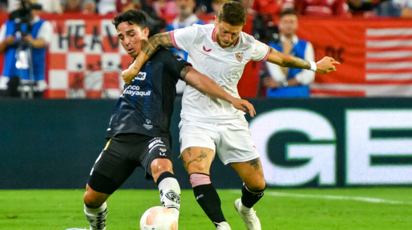 Lorenzo Faravelli disputa un balón ante Alejandro Gómez en el partido de Independiente del Valle ante Sevilla, el 19 de julio de 2023.