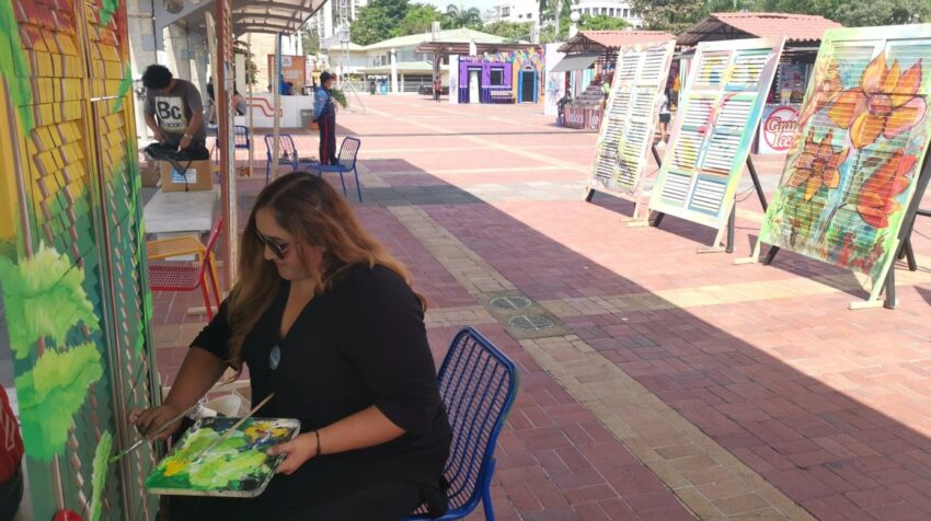 Artistas pintan sobre ventanales coloniales tipos chazas cerca al Hemiciclo de la Rotonda, del Malecón. 