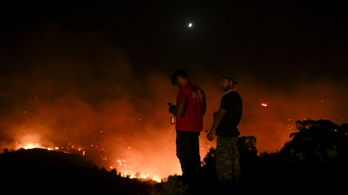 Turistas miran el fuego en la isla de Rodas, en Grecia, el 23 de julio de 2023.