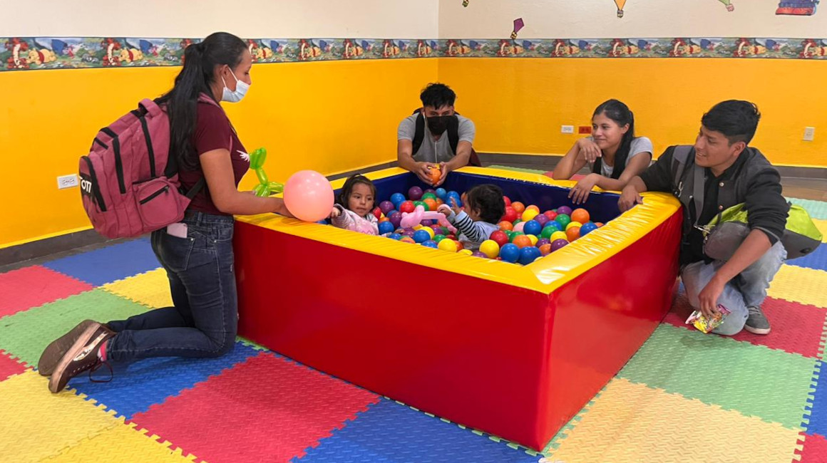 Dos niños y sus cuidadores en el centro infantil que funciona en la Universidad Central, en 2022.