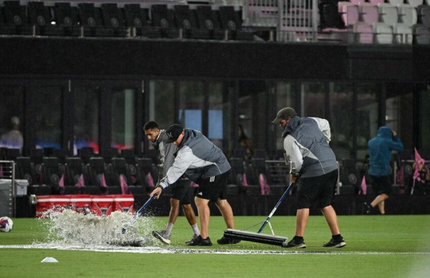 Trabajadores despejan el agua de la cancha del estadio del Inter Miami.