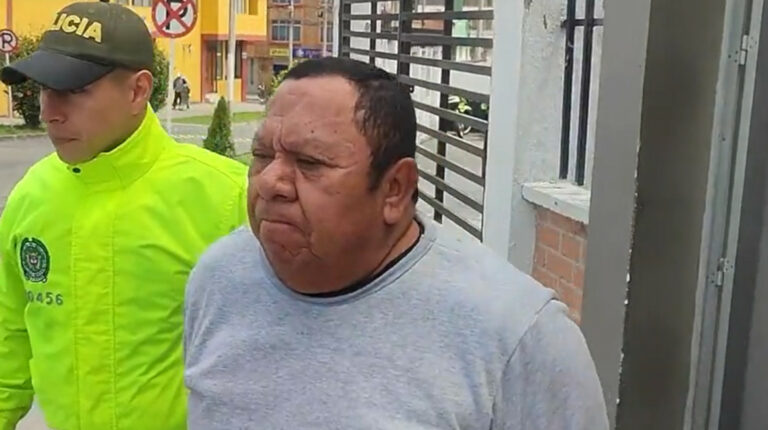 Carlos Meza, alias 'Lechuga', es escoltado por un agente colombiano luego de su captura en Pasto, el 5 de agosto de 2023.