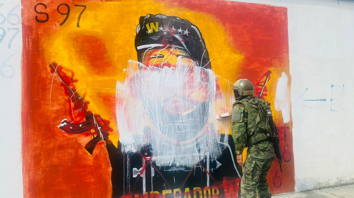 Dos militares borran un mural alusivo a las bandas delictivas que operan en Esmeraldas, el 12 de agosto de 2023.