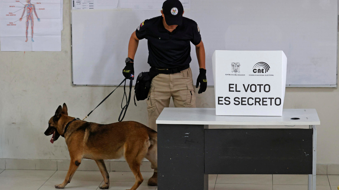 Un can adiestrado inspecciona el recinto electoral donde votó el presidente Guillermo Lasso, el 20 de agosto de 2023. 