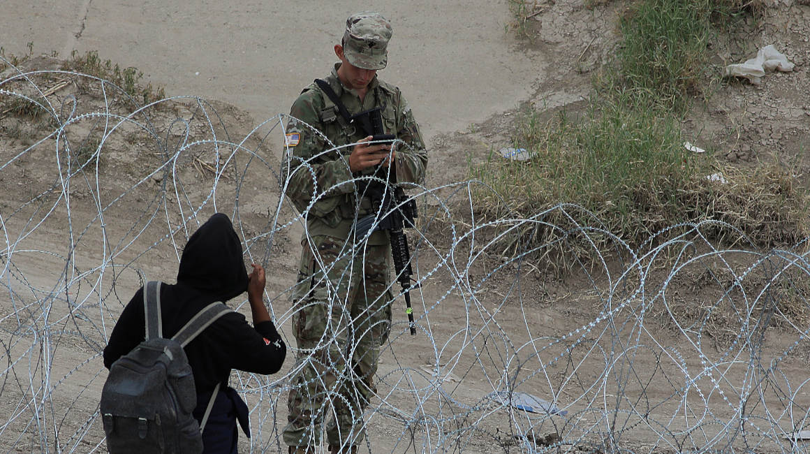 Un migrante permanece a un costado de la frontera con Estados Unidos vigilada por personal de la Guardia Nacional el 13 de septiembre de 2023, en Ciudad Juárez, México.