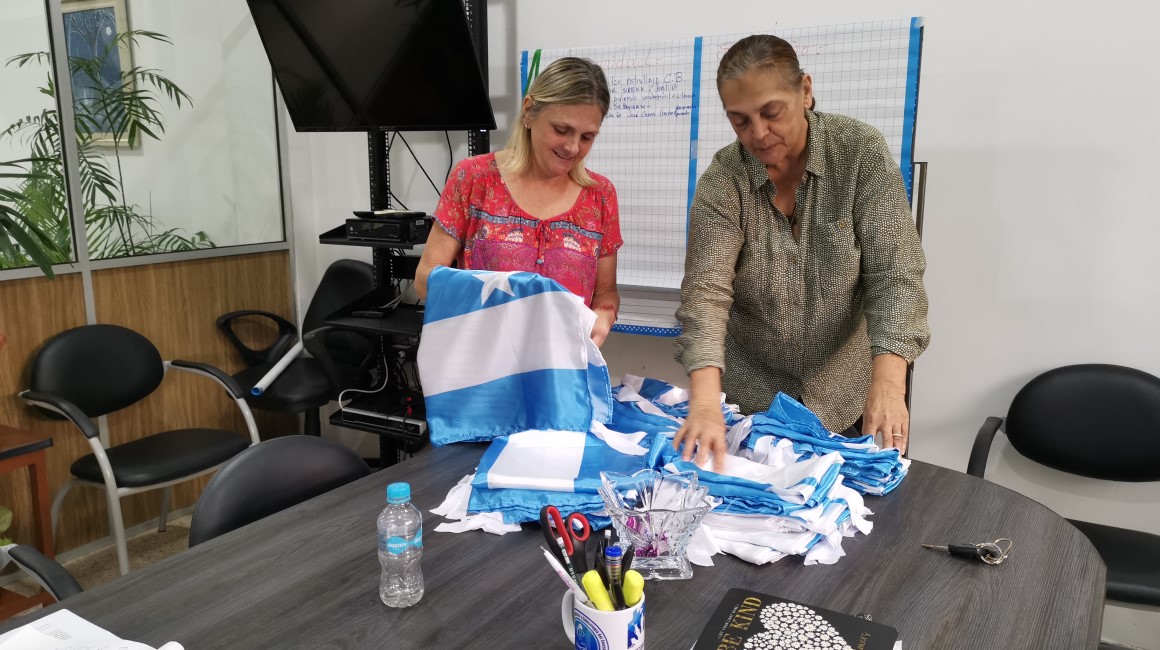 Renate Schenker y Mónica Vallejo, del Comité Barrial Los Ceibos, preparan banderas de Guayaquil para colocar en el barrio por las fiestas de octubre. 