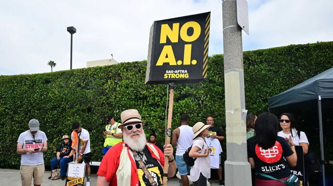 El actor, director y director de fotografía Mark Gray sostiene un cartel que dice "No A.I.", durante la protesta de escritores y actores.