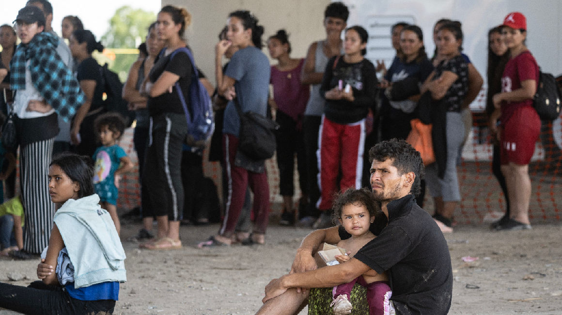 Migrantes esperan ser procesados ​​por la Patrulla Fronteriza de EE. UU., en un centro de procesamiento debajo de un puente en Eagle Pass, Texas, el 25 de septiembre de 2023.