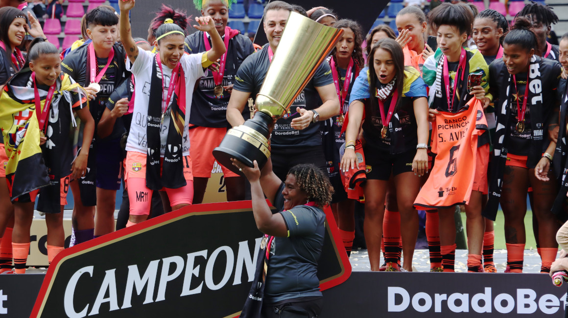 La directora técnica Wendy Villón levanta el trofeo de campeón de la Superliga femenina 2023.