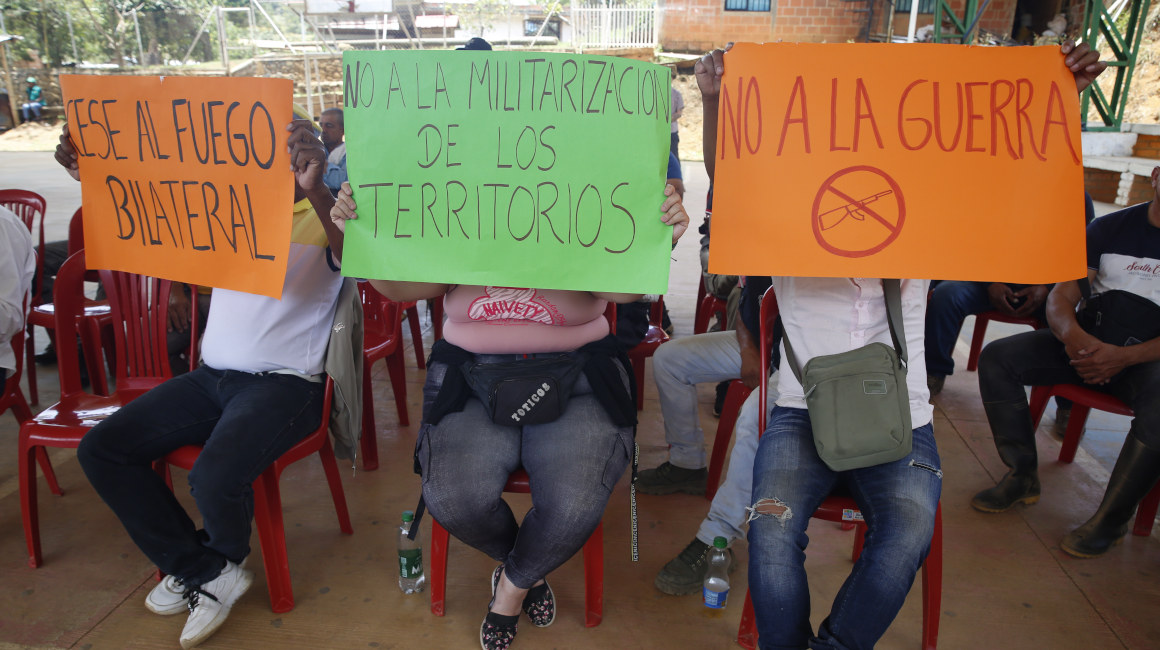 Personas sostienen carteles durante una mesa de diálogos entre el Gobierno colombiano y las disidencias de las FARC, en Suárez (Colombia), el 19 de septiembre de 2023.