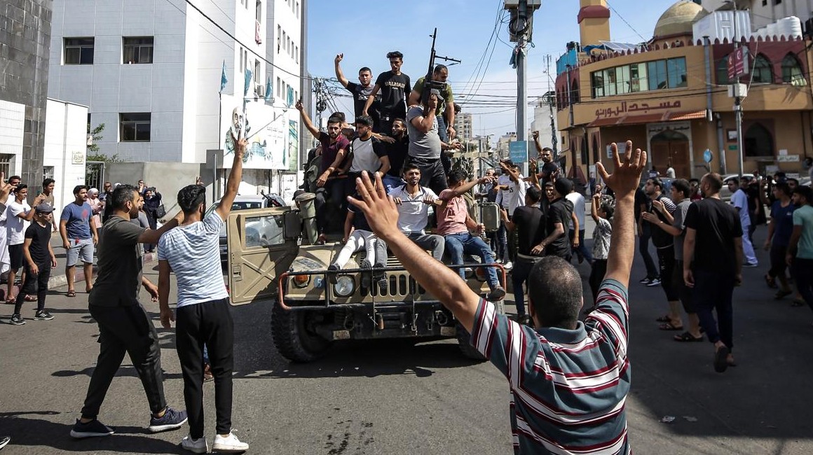 Palestinos viajan en un jeep militar israelí en las calles de Gaza durante el asalto a los asentamientos israelíes por parte de militantes de Hamás.