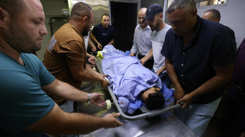 Varios hombres cargan el cuerpo de un joven fallecido por los bombardeos de Israel en el lado palestino, el 13 de octubre de 2023.