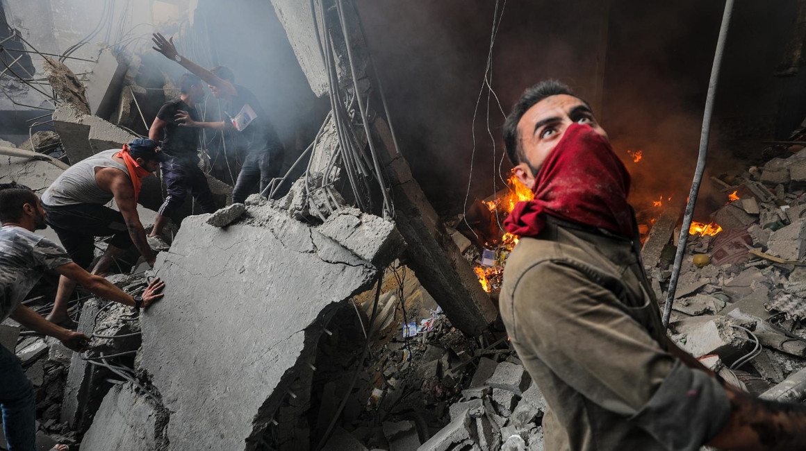 Personas buscan entre los escombros luego de un bombardeo del ejército israelí en Gaza, el 14 de octubre de 2023.