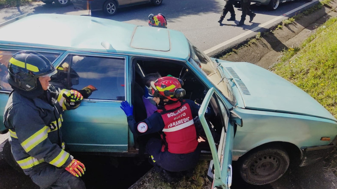 Dos bomberos brindan atención a una mujer durante un accidente de tránsito en Quito, el 15 de octubre de 2023.