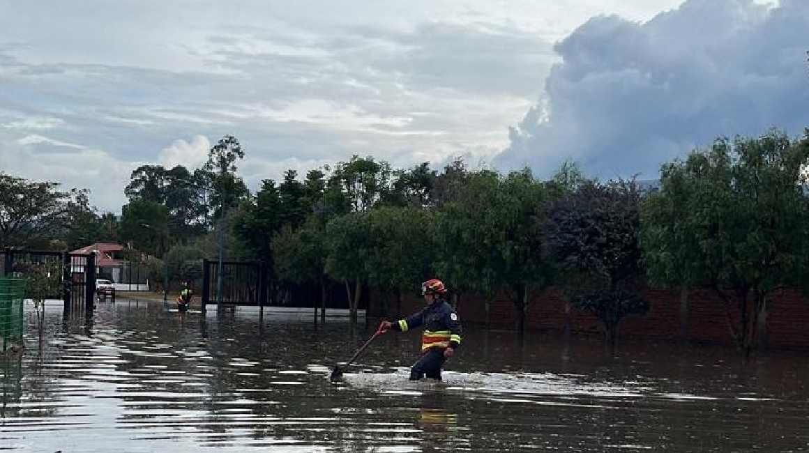 Un bombero actúa frente al desbordamiento de una quebrada en Tumbaco el 9 de octubre de 2023.