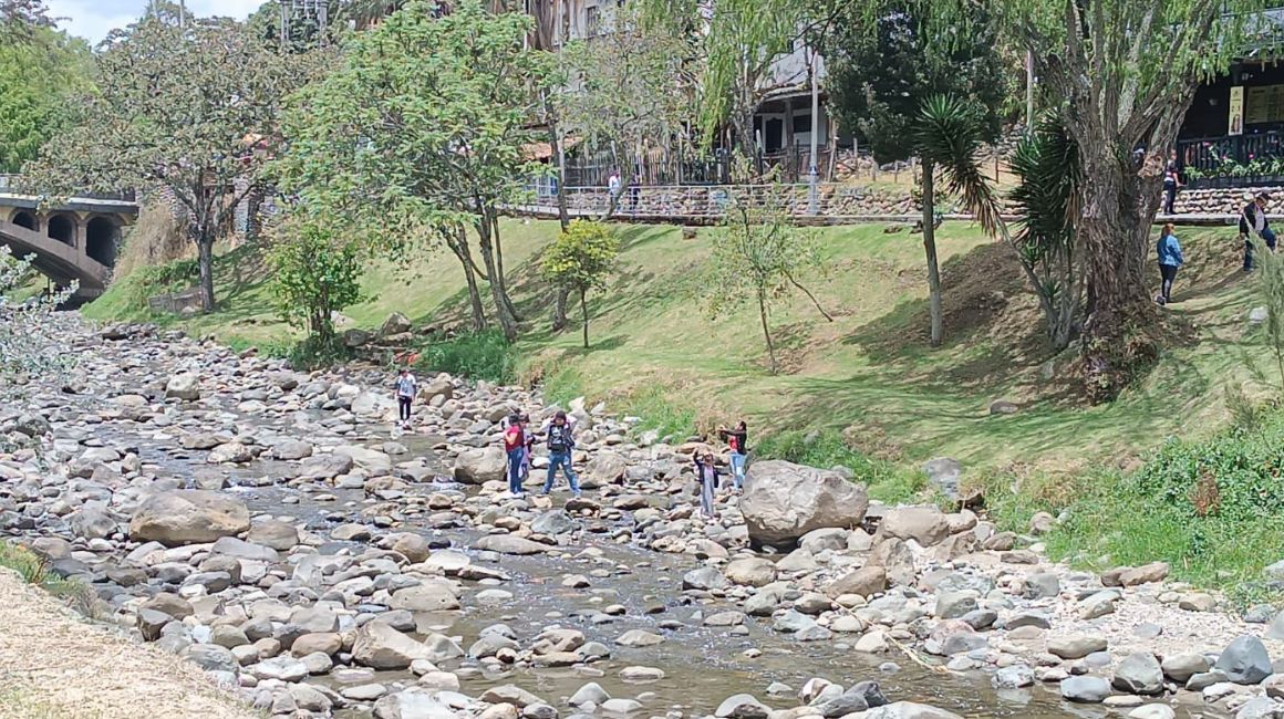 Personas atraviesan el río Tomebamba, casi sin agua, la mañana del domingo 5 de noviembre.