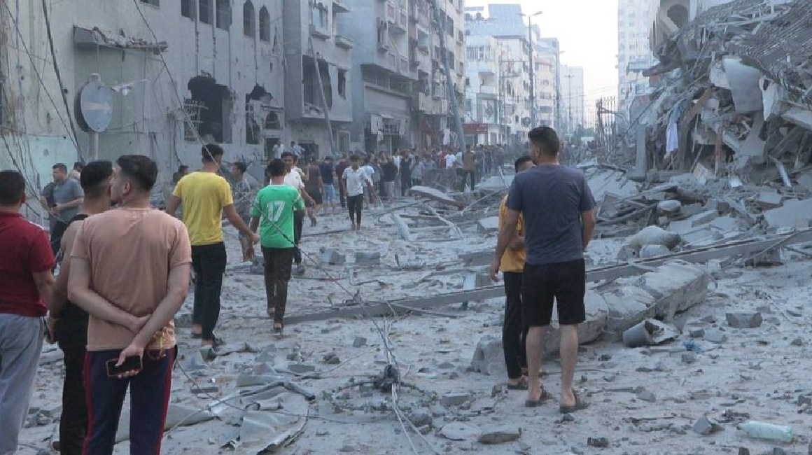 Hombres caminando a través de una zona gravemente dañada de Gaza en noviembre 2023