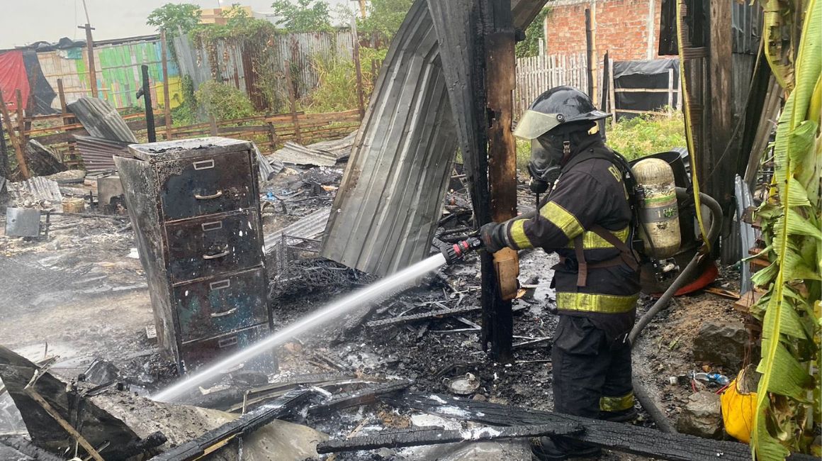 Un bombero intenta apagar un incendio en una vivienda en Durán, Guayas, el 14 de noviembre de 2023.