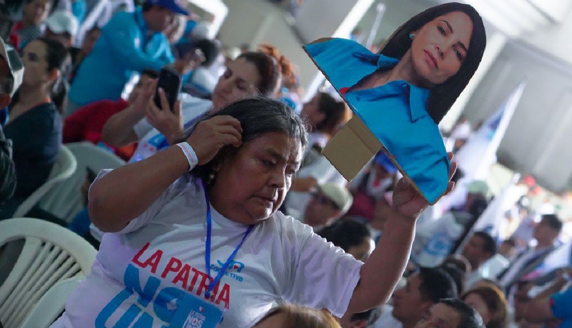 Participante de la convención de la Revolución Ciudadama sostiene una imagen de Luisa González.