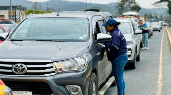 Un agente de la ATM junto a un vehículo en la vía a la Costa, Guayaquil.